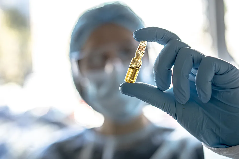 Lab technician holding glass ampoule