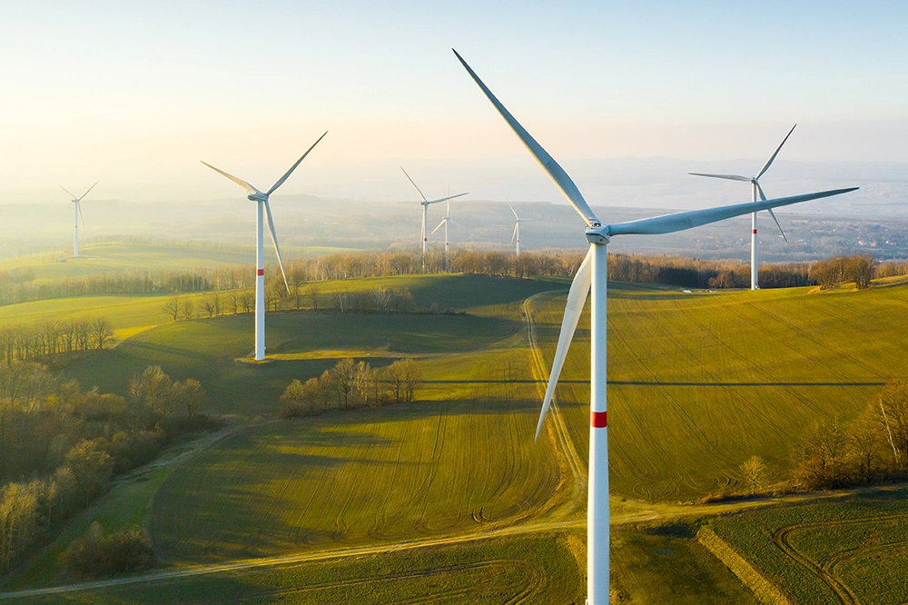 Panoramic view of a wind farm with hills behind